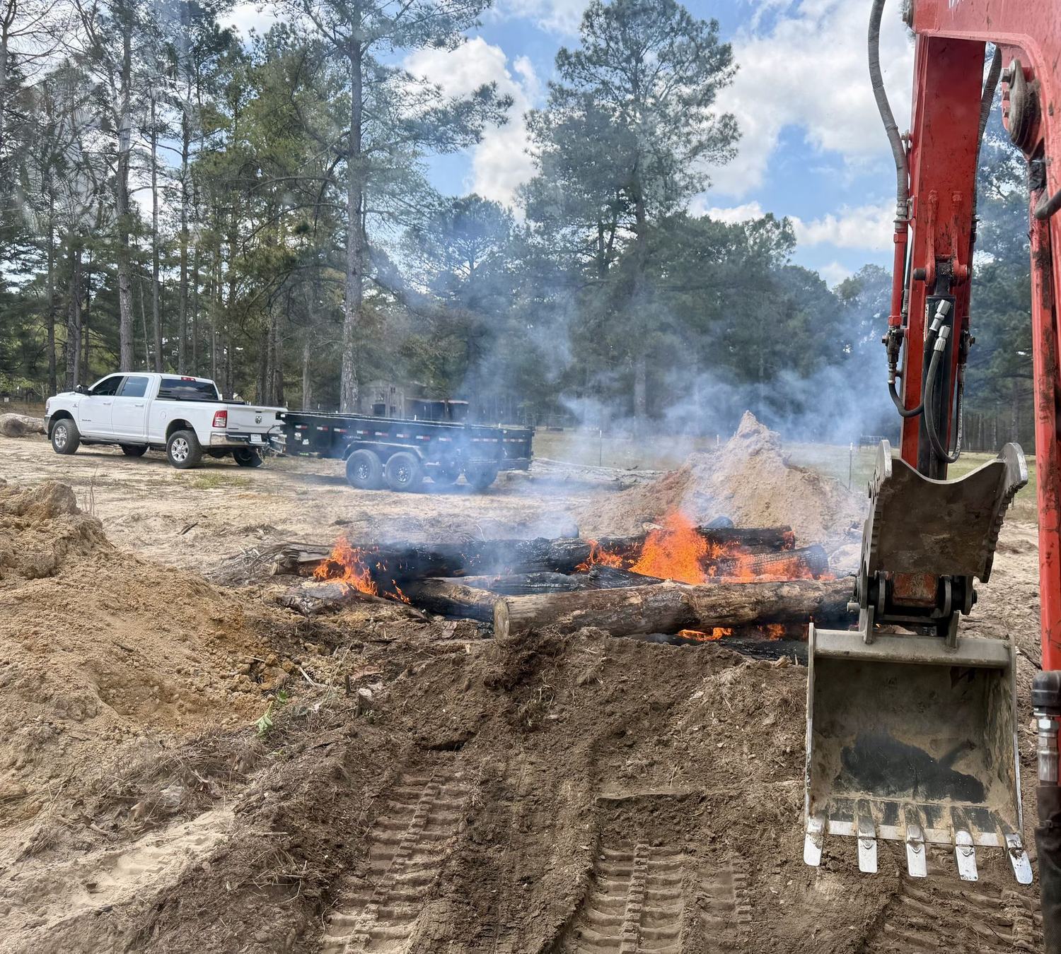 Excavator burning off cleared debris during land clearing